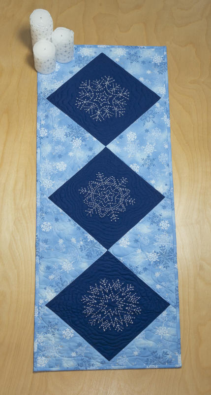 Sashiko Snowflake table runner kit. Kit includes 3 pre-printed patterns and 1/2 yard of fabric for background and binding.  Backing and one skein of thread Not included. We have the thread. Pattern included. 14"x 39" $30