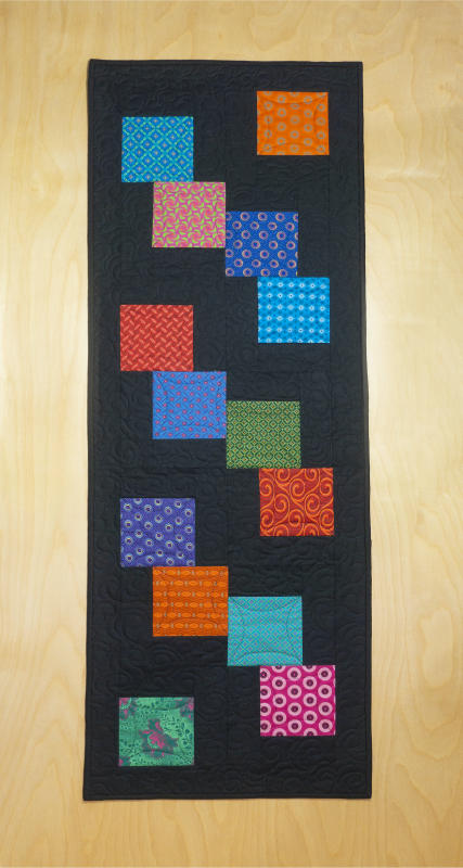 Kit includes Shweshwe fabric squares from South Africa & black solid fabric for the background. Binding and pattern included.  Fabrics in kits are subject to change. Finished size 16.5"x48" $27
