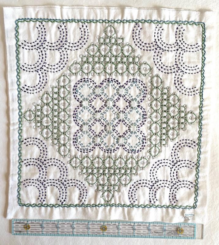 Drop with blue, green, purple & gray thread on white Sashiko fabric. Stitched through 2 layers. Needs a back. $20.00
