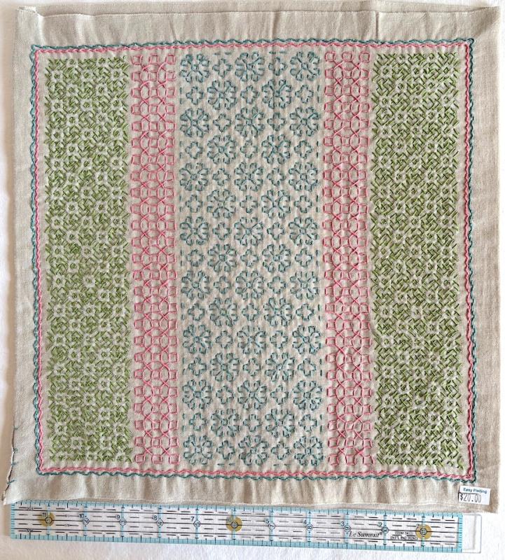 Daisy with bright green, pink & blue thread on natural/brown Sashiko fabric. Stitched through 1 layer. Has a solid natural/brown back $20.00